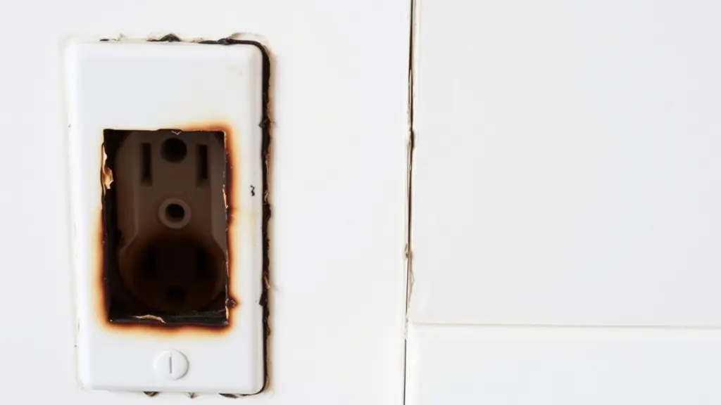 Faint scorch discolouration on the face of a wall outlet cover plate