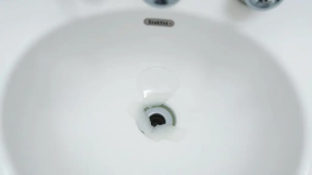 Water standing in a bathroom sink above a slow-draining pop-up stopper